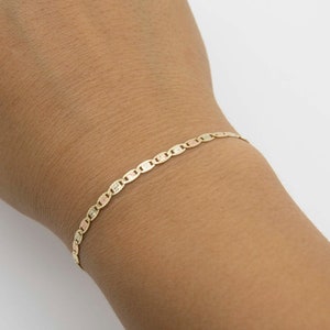 K&ouml;nnte beinhalten: Ein goldenes Armband mit einem Ankerkettenmuster. Das Armband besteht aus drei verschiedenen Goldt&ouml;nen.