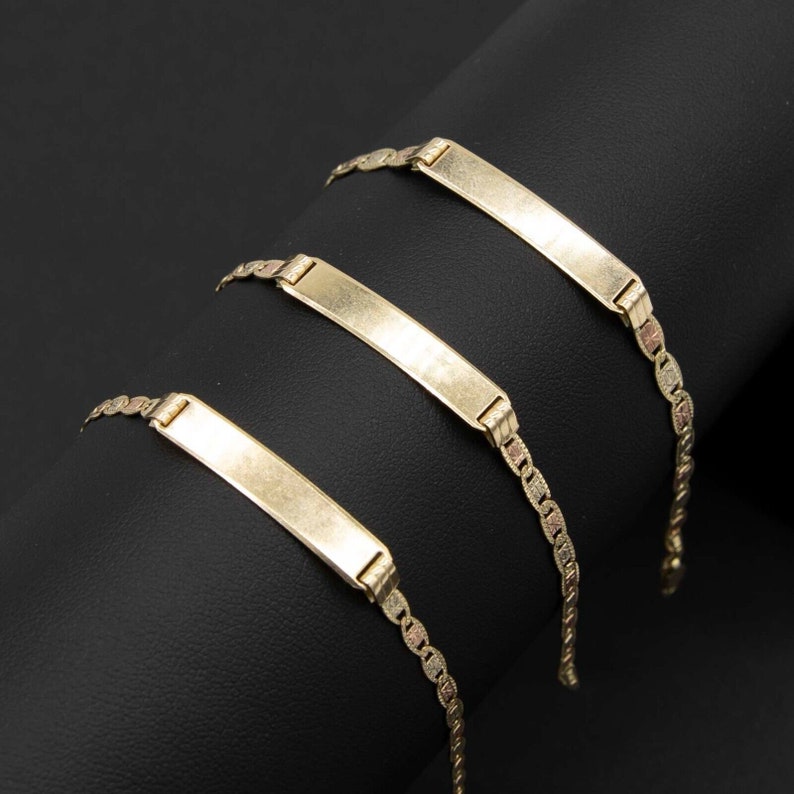 May include: Three gold chain bracelets with a rectangular nameplate charm. The nameplates are blank and ready to be engraved.
