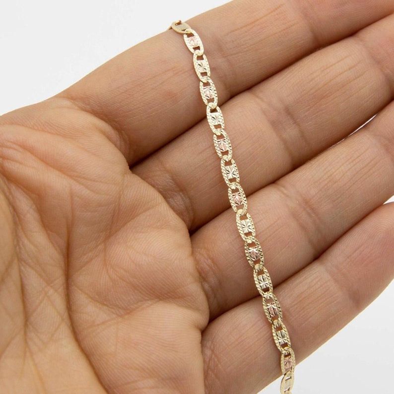 Puede incluir: Un collar de cadena de oro y oro rosa con un dise&ntilde;o de eslab&oacute;n marinero. La cadena es delicada y tiene un acabado pulido.