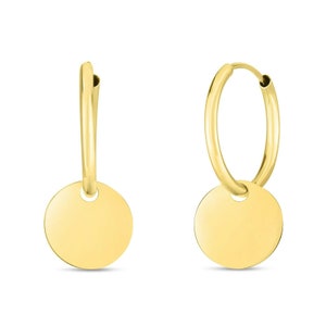 May include: A pair of gold hoop earrings with a round disc charm hanging from each hoop.