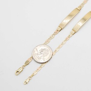 May include: Two gold-toned ID bracelets with a delicate chain design. The chain is a tri-color design with yellow, pink, and white gold. The bracelets are shown next to a US quarter for size reference.