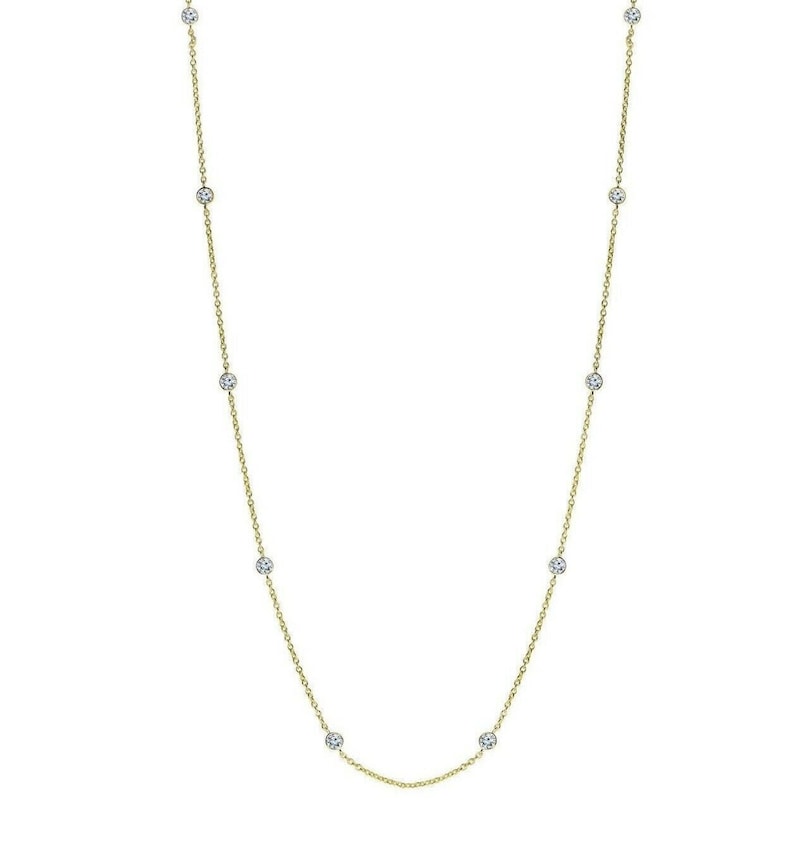 May include: A delicate gold chain necklace with small, clear gemstones spaced evenly along the chain.
