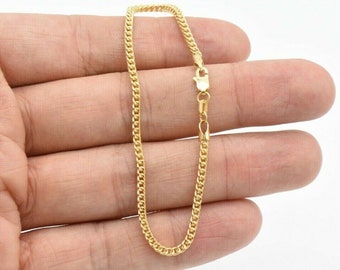 May include: A gold chain bracelet with a curb link design. The bracelet is approximately 7 inches long.
