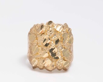 May include: A gold ring with a textured, nugget-like design. The ring is square shaped and has a shiny finish.