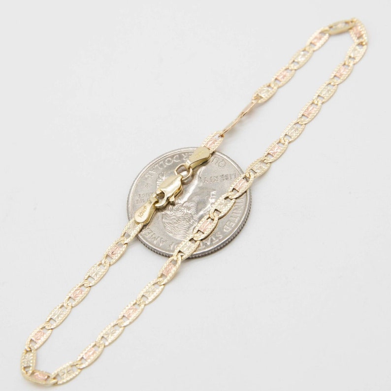 Puede incluir: Un brazalete de cadena de oro con un dise&ntilde;o tricolor. La cadena est&aacute; hecha de oro amarillo, rosa y blanco. El brazalete mide aproximadamente 18 cm de largo y se muestra junto a una moneda de 25 centavos de d&oacute;lar estadounidense para comparar el tama&ntilde;o.
