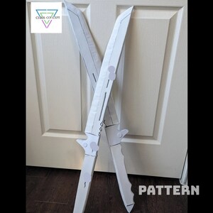 May include: Two white cardboard sword patterns, crossed over each other, with the word "PATTERN" printed in black at the bottom of the image.