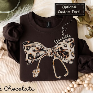 Personalizable Coquette Nurse Sweatshirt, Leopard Print Stethoscope Bow | Gift for Nurse, Nursing Student, Graduation, Appreciation, CNA