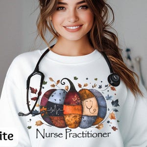 May include: White sweatshirt with a colorful pumpkin design featuring a stethoscope and the words "Nurse Practitioner." The pumpkin is made of patchwork with fall leaves around it. A black stethoscope is around the neck.