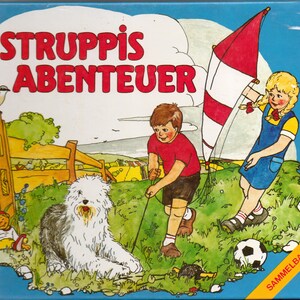 Könnte beinhalten: Ein bunter Buchumschlag mit dem Titel "Struppis Abenteuer" in roten und weißen Buchstaben. Der Umschlag zeigt eine Comic-Illustration eines Mädchens mit einem roten und weißen Drachen, eines Jungen mit einem roten Shirt, eines Hundes und eines kleinen Holzspielzeugs.