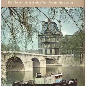 Könnte beinhalten: Vintage Reisebuchcover mit dem Wort "PARIS" in großen, cremefarbenen Buchstaben. Das Bild zeigt ein Boot auf einem Fluss, eine Steinbrücke und ein historisches Gebäude. Der Text "Das Gesicht einer Stadt / Von Martin Hürlimann" ist ebenfalls sichtbar.