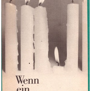 Könnte beinhalten: Ein Buchcover mit einem Schwarzweißfoto von vier brennenden Kerzen. Der Text auf dem Cover lautet "Wenn ein Mensch stirbt..."
