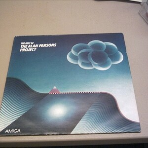 Könnte beinhalten: Ein Vinyl-Plattencover mit einem blauen und schwarzen Design. Das Album trägt den Titel "The Best of The Alan Parsons Project" und zeigt ein stilisiertes Bild einer Wolke und einer Bergkette. Das Album wurde auf dem Label Amiga veröffentlicht.