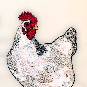May include: Embroidered image of a white chicken with a red comb and wattle. The chicken has black markings on its wings and tail feathers. The chicken is standing on yellow legs with black claws.