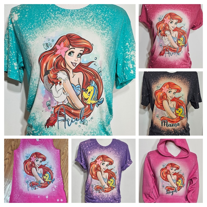 Puede incluir: Un conjunto de seis camisetas con un dise&ntilde;o salpicado de lej&iacute;a con una imagen de dibujos animados de Ariel de La Sirenita. Las camisetas son de varios colores, incluyendo turquesa, rosa, negro, morado y rosa. Las camisetas tienen diferentes estilos, incluyendo una camiseta, un top sin mangas y una sudadera con capucha. Las camisetas est&aacute;n personalizadas con los nombres "Ariel", "Mama" y "Layla".