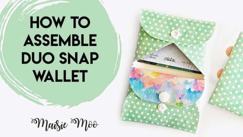 May include: A green fabric wallet with white polka dots and a white snap closure. The wallet is open to reveal a colorful floral print lining and a white card inside. The text "HOW TO ASSEMBLE DUO SNAP WALLET" is written in black on a green circle with a white outline. The text "Maisie Moo" is written in black cursive below the circle.