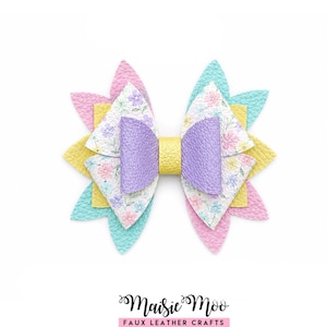 May include: A multi-layered hair bow featuring textured faux leather petals in pastel pink, yellow, and turquoise. The centre layers display a white floral print with purple, pink, and blue flowers, finished with a lavender bow and yellow centre band. Maisie Moo Faux Leather Crafts.