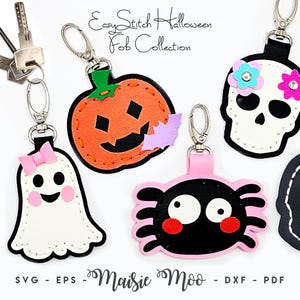 May include: A collection of Halloween-themed key fobs featuring a white ghost with a pink bow, an orange pumpkin with a purple bat, a black spider with pink accents, and a white skull with pink and blue flowers, all with metal lobster clasps.