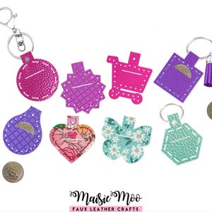 May include: A collection of faux leather coin pouches in various shapes including circles, hearts, butterflies, and shopping carts. These colorful pouches feature stitched details, metal key rings, and some include tassels. Two silver coins are visible.