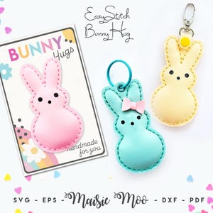 Può includere: Tre oggetti a forma di coniglio: uno rosa su un cartoncino con la scritta Bunny Hugs, uno turchese con un fiocco rosa e un anello blu, e uno giallo con una chiusura argentata. Il testo EasyStitch Bunny Hug e Maisie Moo SVG EPS DXF PDF è visibile.