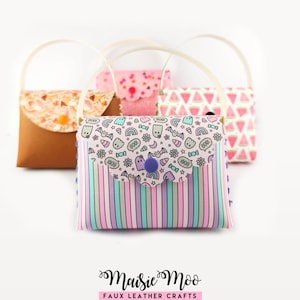 Può includere: Una collezione di quattro piccole borse con manici arcuati e patte smerlate. La borsa in primo piano presenta un corpo a righe pastello e una patta con un motivo di fantasmi, pipistrelli, arcobaleni e caramelle. Chiusura con bottone a pressione.
