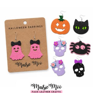 Könnte beinhalten: Eine Sammlung von Halloween-Ohrringen aus Kunstleder. Die Ohrringe umfassen rosa Geister mit schwarzen Schleifen, orangefarbene Kürbisse, schwarze Katzen, lila Schädel mit Blumen, eine schwarze Spinne und einen schwarzen Glitzerschädel. Die Ohrringe werden auf einer braunen Karte mit der Aufschrift "Halloween Earrings" präsentiert.
