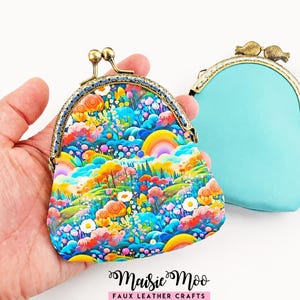 May include: Two coin purses with metal kiss-lock clasps. One purse features a vibrant, multi-colored landscape print with flowers, trees, and a rainbow. The second purse is solid turquoise. The text Maisie Moo Faux Leather Crafts is at the bottom.