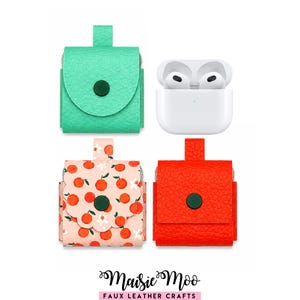 Pode incluir: Quatro capas de AirPod em couro sintético, em verde-azulado, pêssego com estampa de laranja e vermelho, com uma capa de AirPod branca. Cada capa tem um fecho de botão e uma presilha. A capa de pêssego tem uma borda ondulada. A marca "Maisie Moo" está na parte inferior.