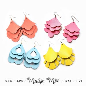 May include: Four pairs of layered earrings in coral, pink, light blue, and yellow. The coral and pink pairs feature scalloped edges, the light blue pair has heart-shaped cutouts, and the yellow pair has fringe-style edges. Text reads Maisie Moo.