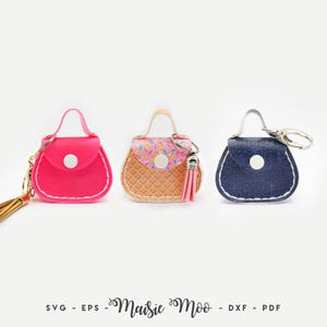 Peut inclure: Trois porte-cl&eacute;s en forme de mini-sacs &agrave; main, rose, en forme de cornet de glace et bleu denim. Chacun a une petite poign&eacute;e, une fermeture &agrave; bouton et un porte-cl&eacute;s dor&eacute; ou argent&eacute;. Le sac en forme de cornet de glace a un pompon rose.