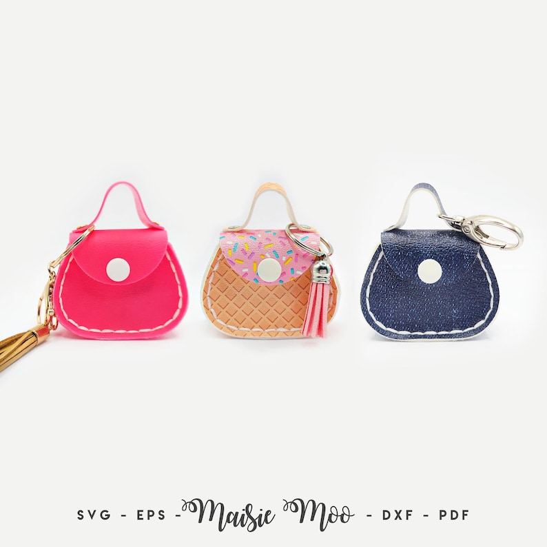 Peut inclure: Trois porte-cl&eacute;s en forme de mini-sacs &agrave; main, rose, en forme de cornet de glace et bleu denim. Chacun a une petite poign&eacute;e, une fermeture &agrave; bouton et un porte-cl&eacute;s dor&eacute; ou argent&eacute;. Le sac en forme de cornet de glace a un pompon rose.