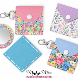 May include: Four small faux leather pouches and a circular mirror. Two pouches have floral patterns with pink or blue flaps and metal clasps. One pouch has a lavender floral flap, one is solid blue, and the mirror has a floral border. Text reads Maisie Moo FAUX LEATHER CRAFTS.