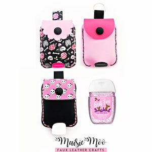May include: Three rectangular faux leather hand sanitizer holders with snap closures and key rings, featuring pink, black, and white patterns of skulls, bones, and roses. A clear plastic bottle of hand sanitizer labeled Best Fins is included.