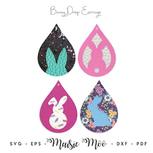 Può includere: Quattro orecchini a goccia etichettati Bunny Drop Earrings e Maisie Moo. Uno è nero con glitter e un coniglio turchese, uno rosa con un coniglio bianco ritagliato, uno rosa con un coniglio bianco e uno floreale con una sagoma di coniglio blu.