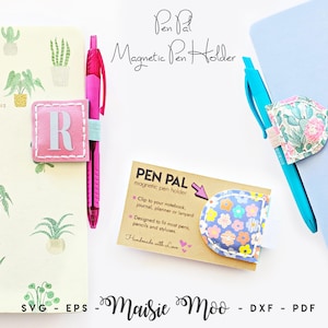 Könnte beinhalten: Eine Kollektion von magnetischen Pen Pal Stiftehaltern mit verschiedenen Stoffmustern, darunter ein rosa Quadrat mit dem Buchstaben R, ein Kaktus-Blumenmuster und ein blaues Blumenmuster. Die Halter sind an Notizbüchern mit Stiften befestigt.