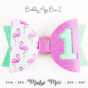 Könnte beinhalten: Eine dekorative Haarschleife mit dem Text Birthday Age Bow 2 und Maisie Moo SVG - EPS - DXF - PDF. Die Schleife hat ein hellblau-weiß gestreiftes Muster mit rosa Flamingos auf einer Seite und eine glitzernde rosa Zahl 1 auf mintgrünem Grund.