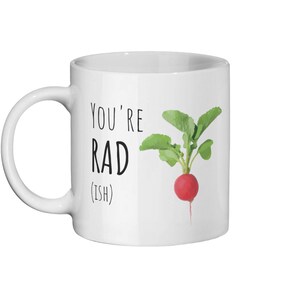 May include: White ceramic mug with black text that reads "You're Rad (ish)" and a cartoon illustration of a red radish with green leaves.