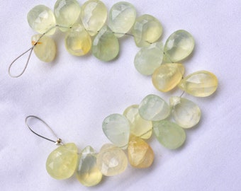 May include: A strand of light green and yellow teardrop-shaped gemstone beads strung on a silver wire.