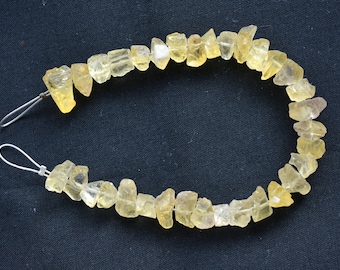 May include: A strand of yellow citrine gemstone beads, strung on a wire with metal clasps. The beads are irregular in shape and size, with a natural, rough-cut finish.