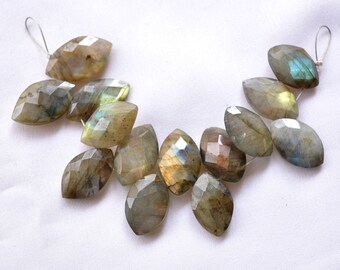 May include: A strand of faceted labradorite gemstone beads in shades of green, gray, and gold. The beads are strung on a silver wire and are ready to be used for jewelry making.