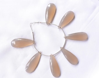 May include: A strand of light gray gemstone beads, each bead is a teardrop shape, strung on a silver wire.