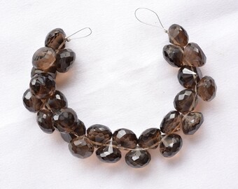 May include: A strand of smoky quartz gemstone beads, faceted and in a teardrop shape. The beads are strung on a wire and are ready to be made into jewelry.