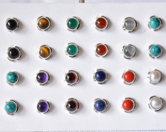 May include: A display of 20 silver stud earrings with various gemstone colors, including black, brown, green, red, blue, white, and turquoise.