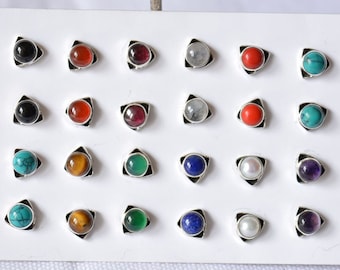 May include: A display of 20 silver earrings with different colored gemstones. The earrings are arranged in four rows of five. The gemstones include black, red, green, blue, white, and turquoise.