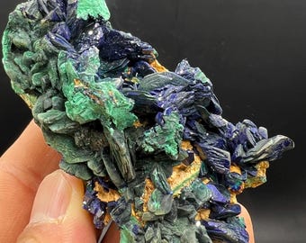 May include: A cluster of green malachite and blue azurite crystals on a natural matrix. The crystals are sharp and well-defined, with a variety of sizes and shapes.