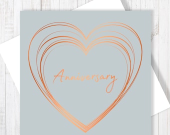May include: A light gray card with a copper colored heart design and the word "Anniversary" written in copper colored script.