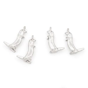 May include: Four silver charms shaped like standing ferrets. The charms have a loop at the top for attaching to a necklace or bracelet.