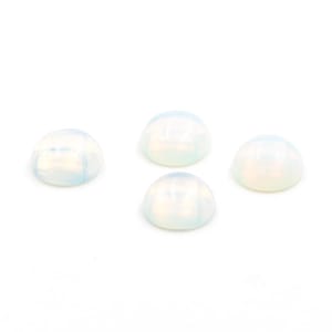 Op de afbeelding: Vier opalescente cabochon edelstenen met een afgeronde, gewelfde vorm. De stenen hebben een melkachtige witte kleur met subtiele iriserende tinten en worden gepresenteerd tegen een witte achtergrond. Deze edelstenen zijn geschikt voor het maken van sieraden.
