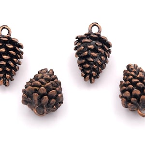 Könnte beinhalten: Vier antike kupferfarbene Tannenzapfen-Anhänger mit einer Öse zum Aufhängen. Die Tannenzapfen sind detailliert und realistisch.