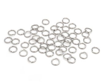 May include: A pile of silver jump rings, a type of jewelry finding used for connecting chains, cords, and other jewelry components.