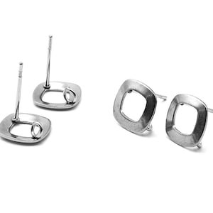 Könnte beinhalten: Zwei silberne quadratische Ohrstecker mit einer kleinen Schlaufe an der Seite. Die Stecker sind so konzipiert, dass sie einen Anhänger oder anderen Schmuck halten.